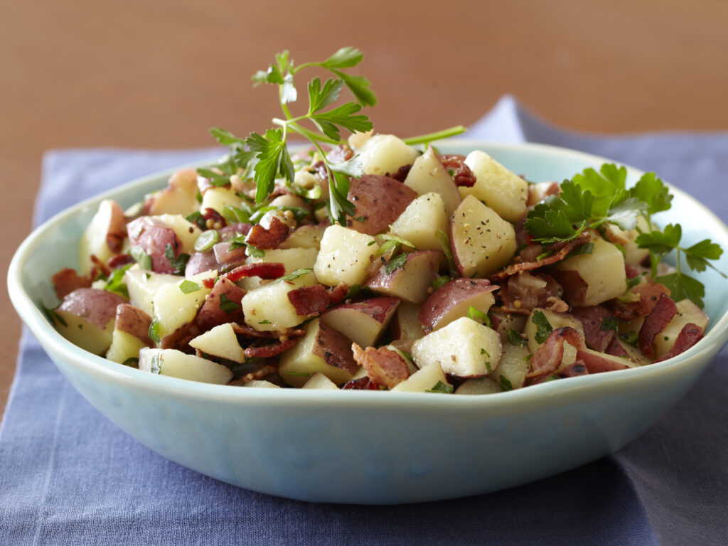 Bobby Flay warm potato salad Food Network photo for Solace atering Group blog post about Oktoberfest german potato salad recipe.